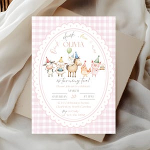 May include: A pink gingham-patterned birthday invitation with an oval frame featuring farm animals wearing party hats. The text reads "Olivia is turning two!" and includes event details.