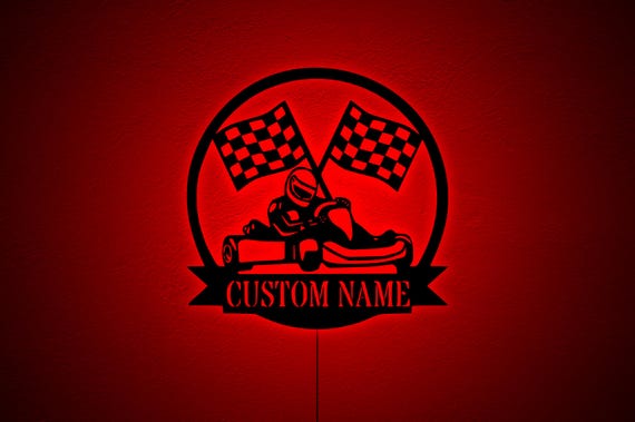Custom LED-lit metal sign shaped around go kart racing — a teen's name literally glowing on their wall in race-day style.