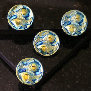 May include: Four blue and gold metallic buttons with a design of two fish facing each other.