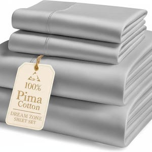 May include: A stack of folded, light gray bed sheets. The sheets are made of 100% Pima cotton and are labeled as a Dream Zone sheet set. The sheets are neatly folded and stacked, with a tag attached.
