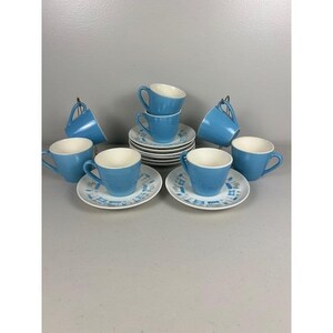 Puede incluir: Un juego de tazas y platillos de té de cerámica azul vintage. Las tazas y los platillos tienen un interior blanco y un exterior azul claro. Los platillos tienen un patrón geométrico. El juego incluye 8 tazas y platillos.