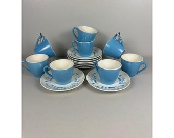 May include: A set of vintage blue ceramic teacups and saucers. The cups and saucers have a white interior and a light blue exterior. The saucers have a geometric pattern. The set includes 8 cups and saucers.
