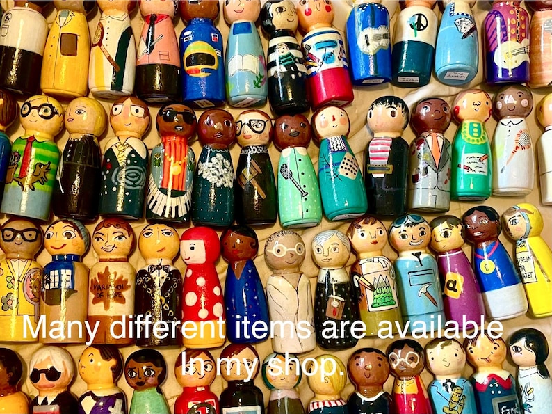 May include: A collection of hand-painted wooden peg dolls, each uniquely designed with different outfits and facial expressions. The dolls are painted in a variety of colors, including yellow, blue, green, and red. The text "Many different items are available in my shop" is visible.