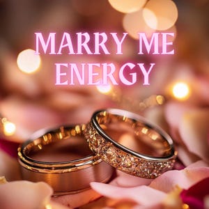 Op de afbeelding: Twee gouden trouwringen, waarvan één met een band van sprankelende stenen, liggen op een bed van roze rozenblaadjes. De woorden "MARRY ME ENERGY" staan in roze tekst boven de ringen, met zachte bokeh-lichten op de achtergrond.