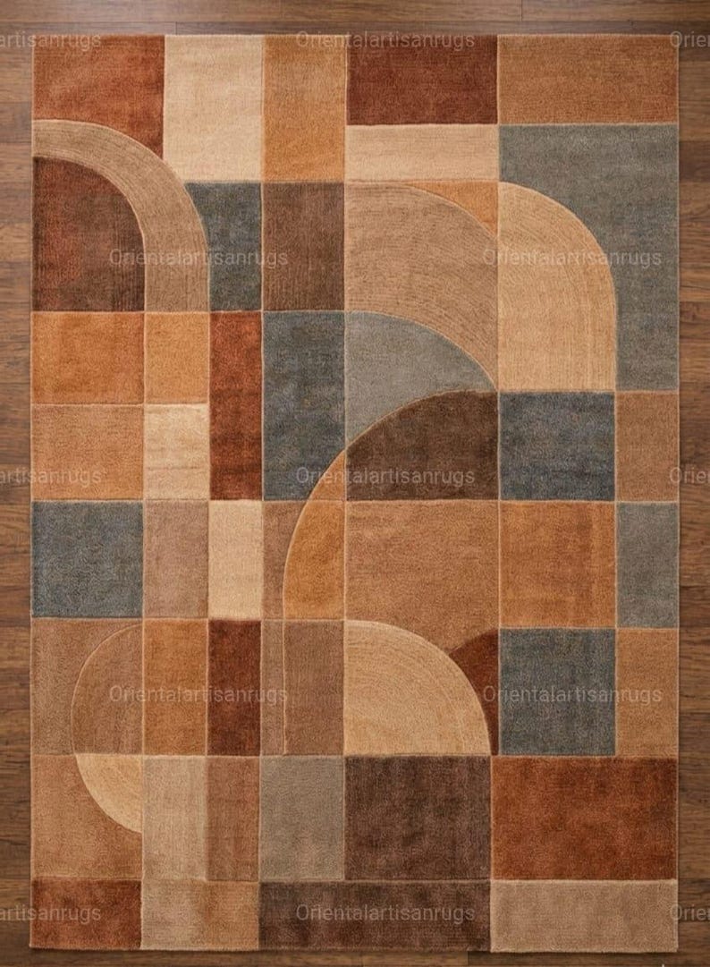 Op de afbeelding: Rechthoekig vloerkleed met een geometrisch ontwerp in bruin, beige en grijstinten. Het patroon bevat vierkanten en gebogen segmenten. Het vloerkleed is gemaakt van een zacht materiaal en is geschikt voor een woon- of slaapkamer. De afmetingen van het vloerkleed zijn in centimeters.