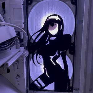 May include: A computer case interior with two illuminated fans. A black silhouette of an anime character is mounted over the fans. The fans emit a soft, cool light, creating a striking contrast with the dark figure.