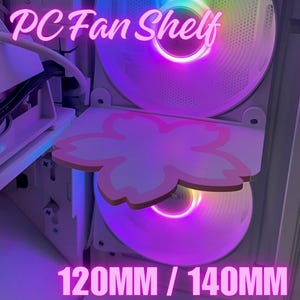 May include: A PC fan shelf with a pink flower design, mounted above two illuminated computer fans. The text "PC Fan Shelf" and "120MM / 140MM" are visible. The fans have a purple and rainbow glow.