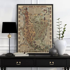 Może przedstawiać: Oprawiona, zabytkowa mapa zatytułowana "Native Tribes of North America, Central America and the Caribbean". Mapa jest w czarnej ramie i zawiera ilustracje rdzennych Amerykanów. Mapa jest wyświetlana na czarnym stole z lampą i dekoracyjnymi wazonami.