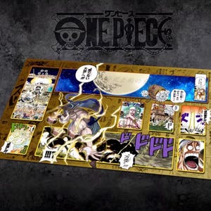 May include: A rectangular playmat with panels of colourful illustrations and Japanese text. The playmat has a gold border and the One Piece logo in the upper centre. The illustrations depict characters and scenes from the One Piece manga series.