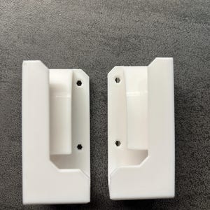 Pu&ograve; includere: Due supporti a parete bianchi e rettangolari con un design a forma di U. Ogni supporto ha un foro per l'hardware di montaggio. I supporti sono realizzati in un materiale liscio e solido e sono progettati per contenere un oggetto.