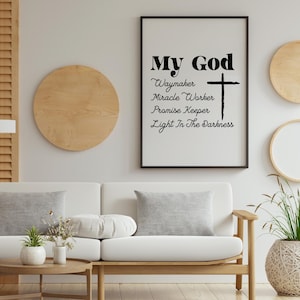 Peut inclure: Une affiche encadr&eacute;e avec les mots "My God" et d'autres phrases, dont "Waymaker" et "Light In The Darkness", en noir. Une croix noire est &agrave; c&ocirc;t&eacute; du texte. L'affiche est affich&eacute;e sur un mur blanc avec un d&eacute;cor en bois et un canap&eacute; blanc.