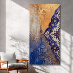 Puede incluir: Una pieza de arte mural rectangular vertical con un diseño dividido. El lado izquierdo muestra un fondo degradado texturizado y desgastado en oro y azul. El lado derecho presenta un intrincado y ornamentado patrón floral azul y blanco.
