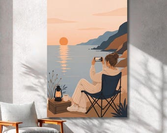 Könnte beinhalten: Ein vertikaler Wandkunstdruck, der eine Person in einem dunkelblauen Klappstuhl an einem Strand bei Sonnenuntergang zeigt. Die Person trägt eine helle Hose und einen Kapuzenpullover und hält ein Smartphone, um den Blick auf das Meer festzuhalten.
