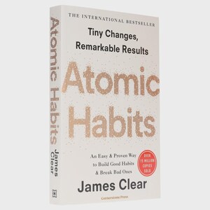 May include: A white book titled Atomic Habits by James Clear with the subtitle Tiny Changes, Remarkable Results and An Easy & Proven Way to Build Good Habits & Break Bad Ones. A red circular badge states Over 15 Million Copies Sold.