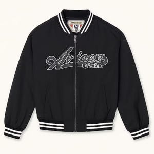 May include: Black bomber jacket with white and black striped trim on the collar, cuffs, and hem. The jacket features a full-length zipper and the word "Aviaex USA" in white script across the chest.