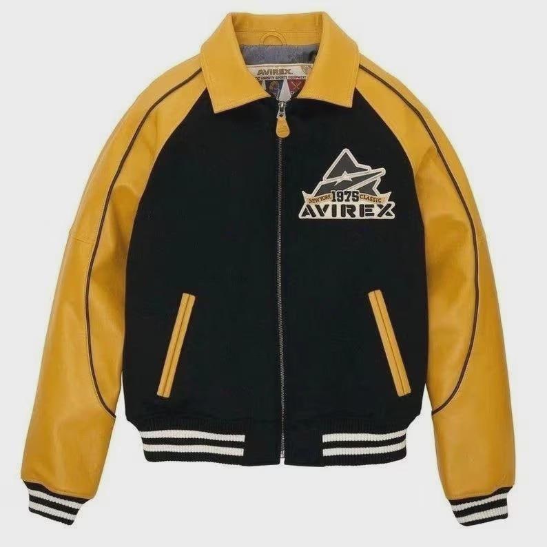 May include: Black and yellow varsity jacket featuring the text "AVIREX" and "1975 Classic". The jacket has a yellow collar and sleeves, with black panels. It has a zip closure, two front pockets, and a striped hem. The jacket is a classic design.