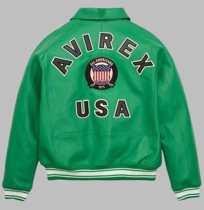 May include: Green leather jacket with the word "AVIREX" arched across the back in white lettering. Below the word "AVIREX" is a circular patch with the American flag and the words "ALL AMERICANS ESTABLISHED 1975". The word "USA" is below the patch.