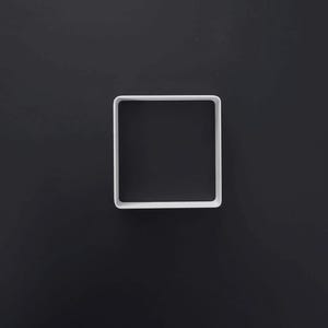 Könnte beinhalten: Ein weißer quadratischer Ausstecher mit abgerundeten Ecken. Der Rahmen ist dünn und gleichmäßig, was eine einfache geometrische Form ergibt. Das Objekt ist in der Mitte hohl und weist eine saubere, glatte Oberfläche sowie eine gleichmäßige Randbreite auf.