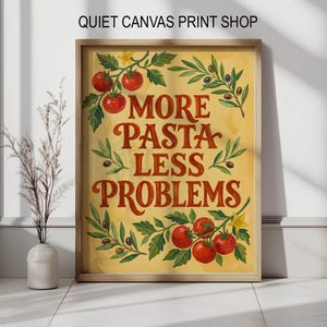 Könnte beinhalten: Ein gerahmter Druck mit dem Text "MORE PASTA LESS PROBLEMS" in Rot, umgeben von Illustrationen von Tomaten und Olivenzweigen. Der Hintergrund ist ein warmes Gelb, und der Rahmen ist hellbraun. Der Text "QUIET CANVAS PRINT SHOP" steht oben.