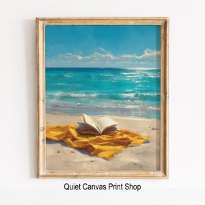 May include: A framed print depicts a serene beach scene. Turquoise ocean waves meet a sandy shore under a bright blue sky with fluffy clouds. A yellow blanket and an open book rest on the sand, inviting relaxation. The text "Quiet Canvas Print Shop" is at the bottom.