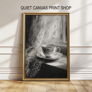 Puede incluir: Impresión en blanco y negro enmarcada de una taza y un platillo en un alféizar, con cortinas de encaje en el fondo. La impresión está en un marco dorado y tiene el texto "QUIET CANVAS PRINT SHOP" en la parte superior.