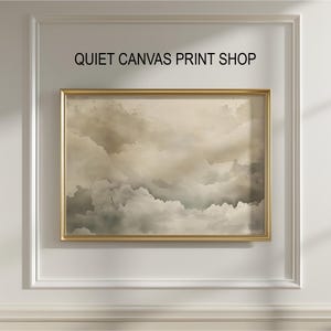 May include: A framed canvas print featuring a cloudy sky in shades of beige, gray, and white. The artwork is enclosed in a gold-colored frame and mounted on a white wall. The text "QUIET CANVAS PRINT SHOP" is above the frame.