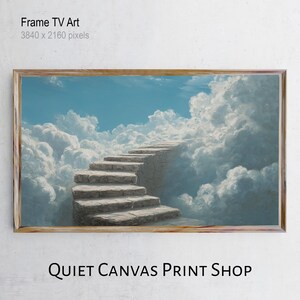 Puede incluir: Una impresión artística digital enmarcada representa una escalera de piedra que asciende hacia un cielo azul brillante rodeado de nubes blancas. La obra de arte está etiquetada como "Frame TV Art" y "Quiet Canvas Print Shop". El marco es de color marrón claro.
