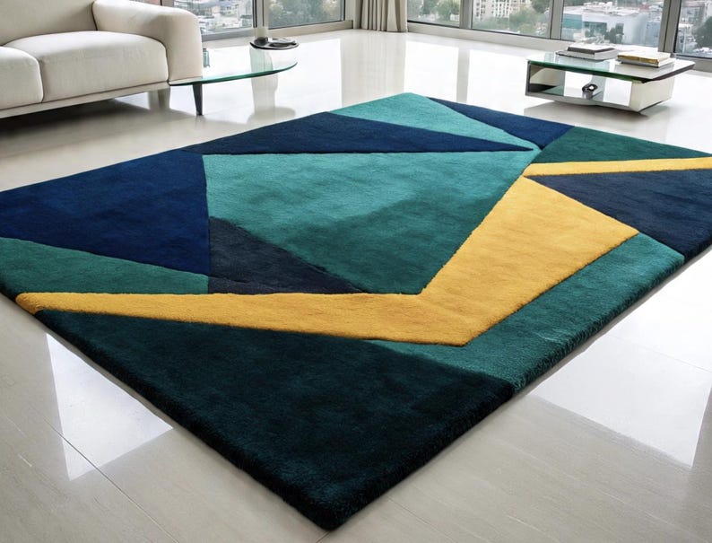 May include: A rectangular area rug with a geometric design. The rug features a pattern of blue, teal, and yellow shapes. The rug is made of a soft, plush material and is suitable for a living room or bedroom.