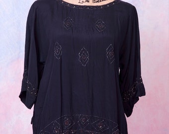 May include: A black silk blouse with a beaded neckline and trim. The blouse has a loose fit and is decorated with geometric patterns of beads.