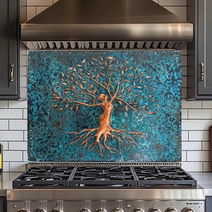 Puede incluir: Un protector contra salpicaduras con diseño de árbol color cobre sobre un fondo turquesa. El árbol tiene ramas y raíces detalladas. El protector está instalado sobre una estufa de gas de acero inoxidable.
