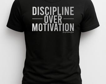 May include: Black t-shirt with the text "DISCIPLINE OVER MOTIVATION" in white block letters. The shirt also has the text "LIMITLESS POWERLIFTING" at the top and the signature "Sam Jue Biondi Queen" at the bottom.
