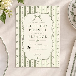 May include: A rectangular birthday brunch invitation card featuring a cream-coloured centre with dark green text and a decorative border. The background has vertical sage green stripes and small bow illustrations. The text reads: Please join us for a birthday brunch in celebration of Eleanor, Saturday April 26, 2027, at 1:00 PM, The Garden Room, at Maple Avenue, Greenwich, Connecticut, kindly RSVP by April 15, 555 012 2380.