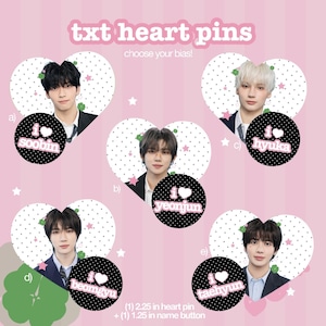 May include: Pink graphic featuring five heart-shaped pins with photos of band members. Each pin has a black circle with the text "I heart" and a member's name. The text "txt heart pins" and "choose your bias!" are at the top. The heart pins are 2.25 inches and the name buttons are 1.25 inches.