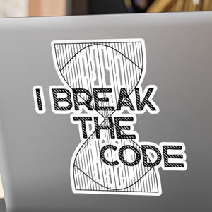 May include: A white sticker on a laptop with the text "I BREAK THE CODE" in a bold, black font. The design includes an hourglass shape with curved lines, suggesting a mathematical or scientific theme.