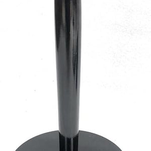 May include: A black wooden display stand with a round base, a slender, cylindrical stem, and a flat, circular top. The stand has a glossy finish and is designed to hold an object.
