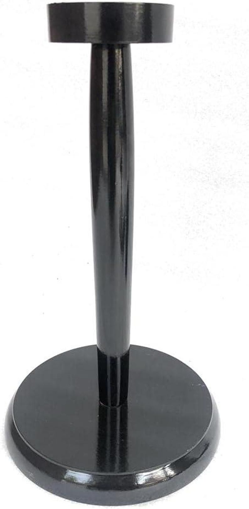May include: A black wooden display stand with a round base, a slender, cylindrical stem, and a flat, circular top. The stand has a glossy finish and is designed to hold an object.