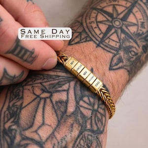 May include: A gold-toned wheat chain bracelet featuring four rectangular beads engraved with the text MY UNCLE MY SECOND DAD. The bracelet is worn on a wrist with visible tattoos.