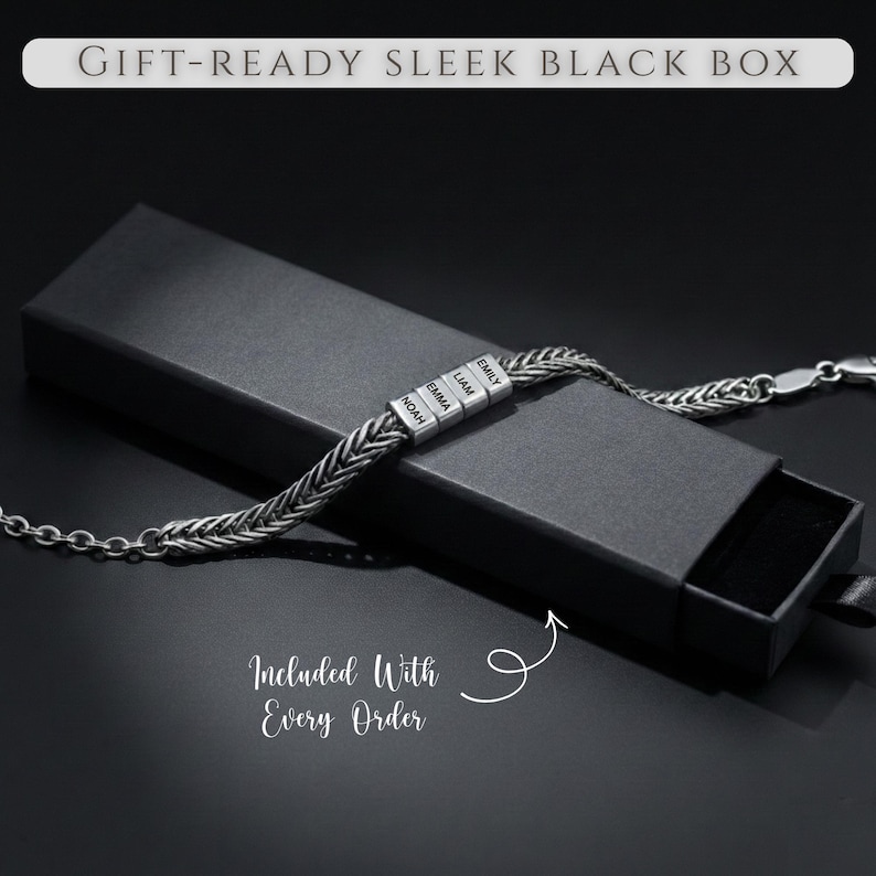 May include: A silver-colored bracelet with braided chain design, featuring personalized name beads, is displayed inside a black gift box. The box has the text "GIFT-READY SLEEK BLACK BOX" and "Included With Every Order".