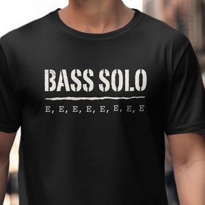 Black t-shirt with "BASS SOLO" and repeated "E" text graphics.