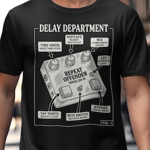 May include: Black t-shirt featuring a detailed illustration of a "Repeat Offender" effects pedal, with labels like "Time Knob" and "Bypass." The design includes the text "Delay Department" and "Model DD-01."