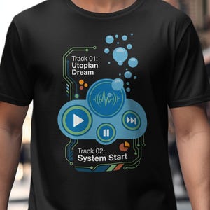 May include: Black t-shirt with a music-themed graphic. The design incorporates play, pause, and skip symbols, alongside the text "Track 01: Utopian Dream" and "Track 02: System Start". The design also features bubbles and circuit board-style lines.