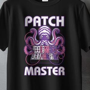 May include: Black t-shirt with a graphic of an octopus-like creature and a synthesizer design. The text "PATCH MASTER" is in white and purple. The shirt is hanging on a wooden hanger.
