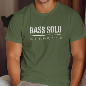 Olive green t-shirt with text "BASS SOLO" and repeated "E"s.