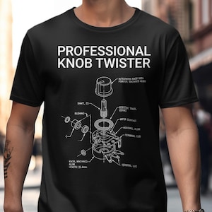 Könnte beinhalten: Schwarzes T-Shirt mit dem weißen Text "PROFESSIONAL KNOB TWISTER" und einer technischen Zeichnung eines Knopfes. Die Zeichnung ist detailliert mit Beschriftungen. Das T-Shirt wird von einer Person getragen.