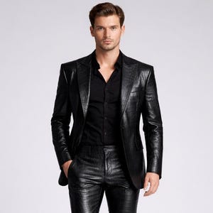 May include: A black leather suit, including a blazer and matching pants, paired with a black button-down shirt. The suit has a textured appearance and is worn with black shoes. The outfit is displayed against a plain background.