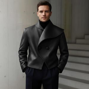 May include: A black leather jacket with a unique, asymmetrical collar and double-breasted button closure. The jacket is paired with a black turtleneck and dark blue trousers. The overall style is modern and sophisticated.