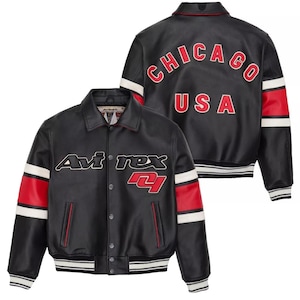 May include: Black leather jacket with red and white accents. Features the text "Avi rex" and a red "4" on the front. The back displays "CHICAGO USA" in red lettering. Includes a button-up closure and a striped hem.