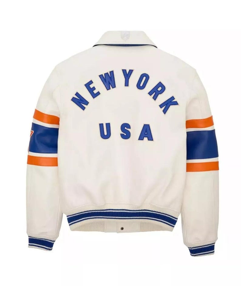 May include: Cream-colored jacket with blue and orange accents. The back features the text "NEW YORK USA" in blue lettering. The sleeves have blue and orange stripes. The jacket has a collar and a blue and white striped hem.