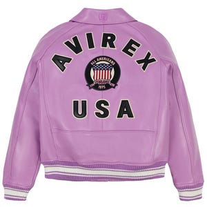 May include: A lavender leather jacket with the word "AVIREX" across the shoulders and "USA" below. The jacket features a patch with the American flag and the words "ALL AMERICANS ESTABLISHED 1975". The cuffs and hem have white and black stripes.