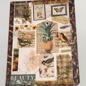 Puede incluir: Un diario decorativo con un diseño de collage que presenta una piña, pájaros, mariposas y elementos florales. El diario tiene un soporte de metal dorado. La portada incluye la palabra "BEAUTY".